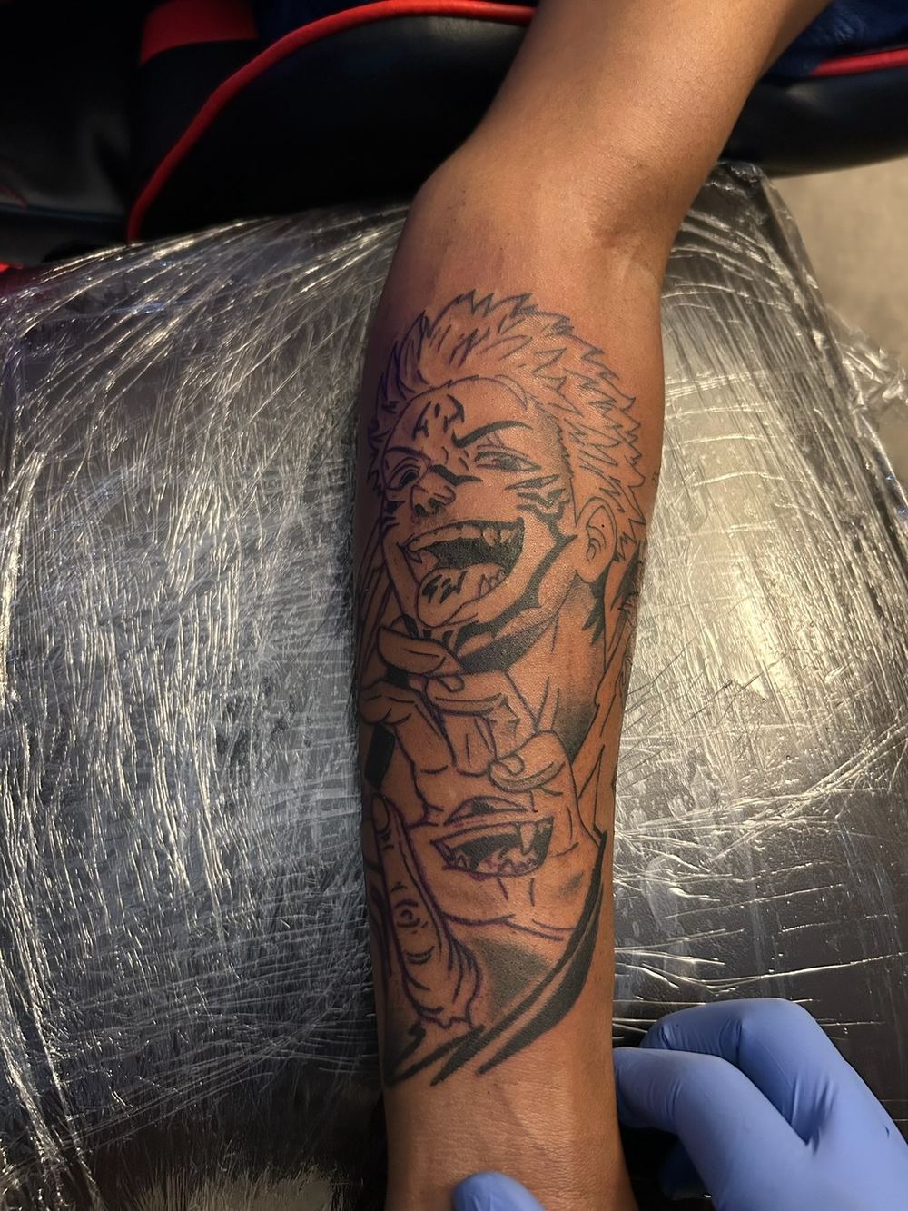 Anime style character arm tattoo