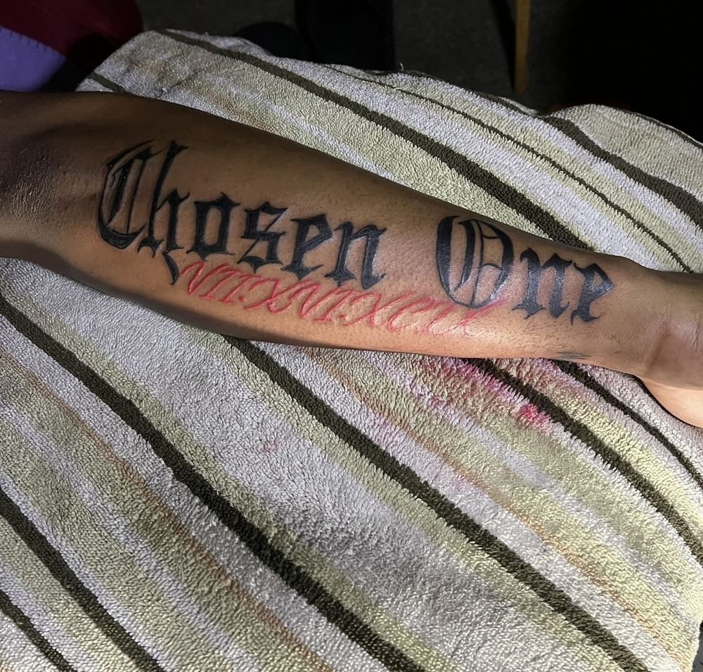 Chosen One gothic lettering forearm tattoo with roman numeral date
