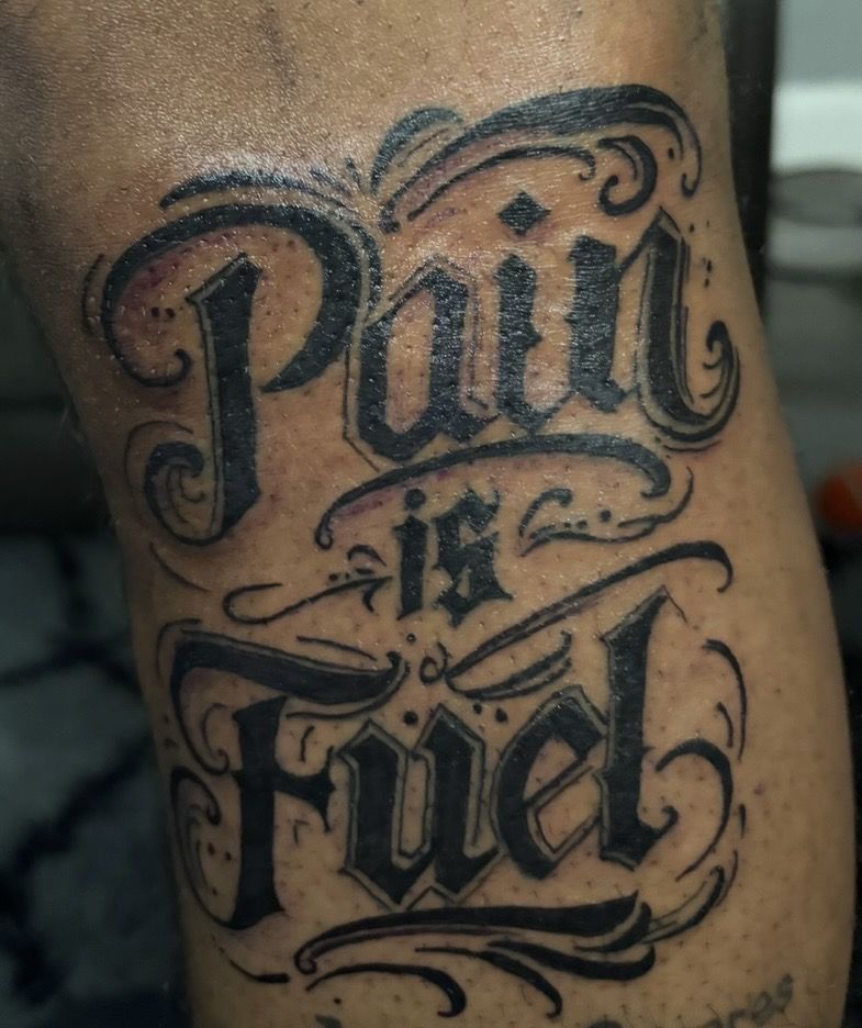 Pain is fuel custom script lettering arm tattoo