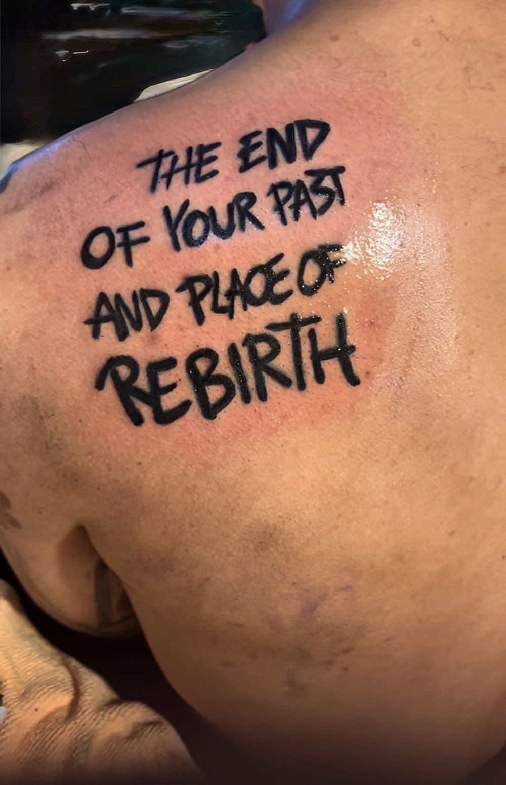 The end of your past and place of rebirth handwritten lettering shoulder tattoo