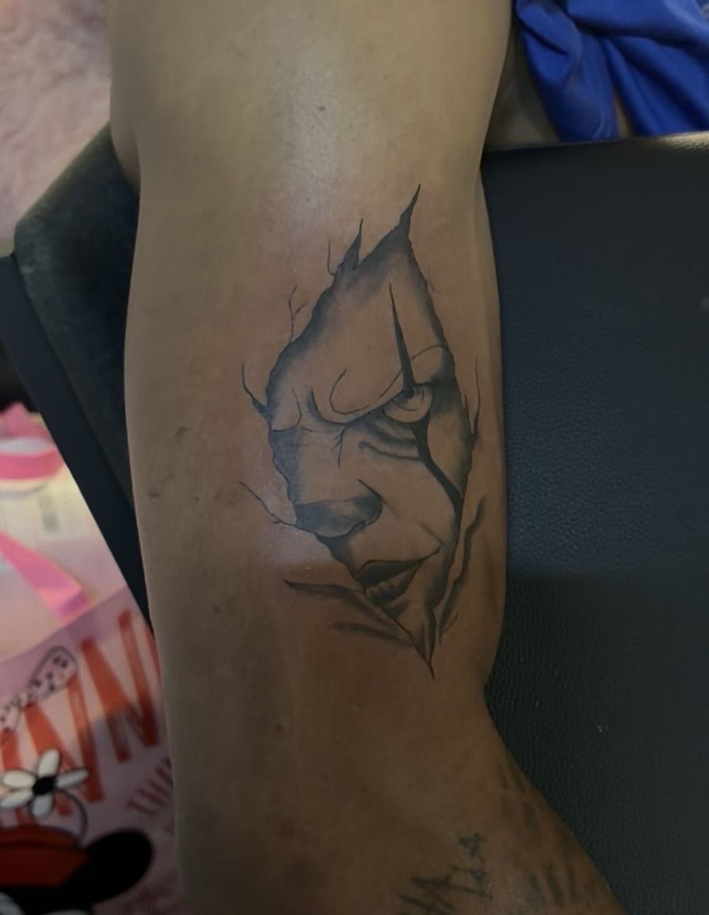 Pennywise horror face illustrative black and grey forearm tattoo